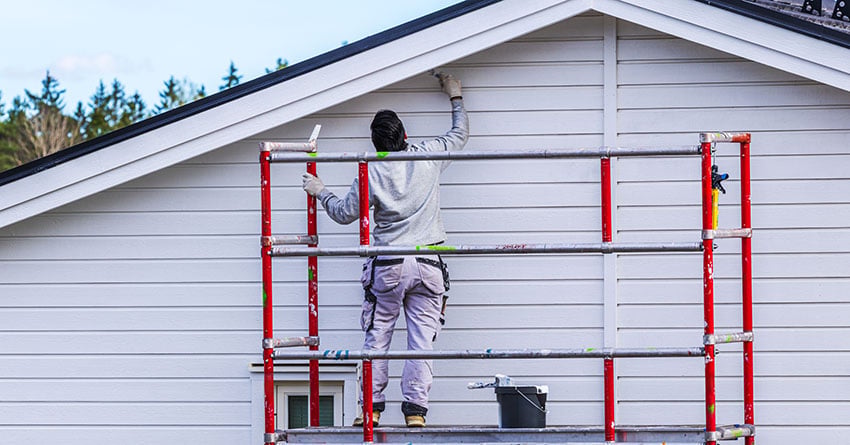 Mann maler hus